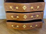 a wooden chest of drawers with gold decorations on it