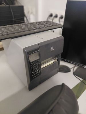 un ordinateur et une imprimante posés l'un à côté de l'autre sur un bureau