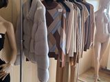 a woman that is standing in front of a rack of clothes