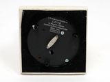an image of a black and white clock sitting on top of a white surface