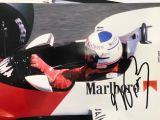 un homme assis dans une voiture de course, coiffé d'un casque