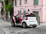 a small white car parked on a cobblestone street