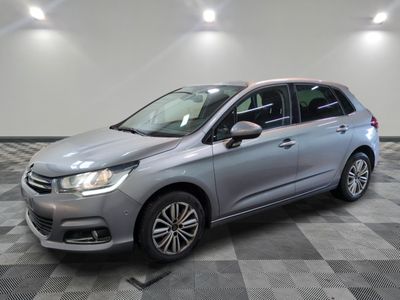 une voiture argentée est garée dans une pièce au sol en damier