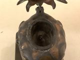 a bronze sculpture of a bird on top of a vase