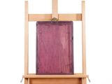 a easel with a painting on it and a book on top of it