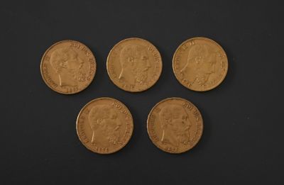 four gold sovereigns on a black background