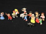 many figurines of different people on a black background