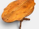 a wooden table with a leaf shaped top on a white background