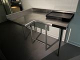 une table en acier inoxydable sur laquelle est posé un plateau