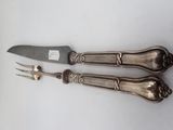 two forks and a knife sitting next to each other on a table