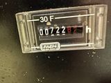 a close up of a clock on the side of a refrigerator