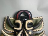 l'image d'un masque en bois orné de cornes