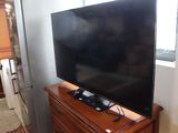 a flat screen tv sitting on top of a wooden dresser