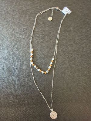 a necklace with a coin on it sitting on top of a table