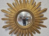 a person taking a picture in a mirror of a sunburst