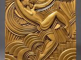 a gold sculpture of a woman sitting on top of a wave