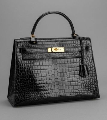 un sac à main en cuir de crocodile noir avec des finitions dorées