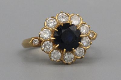 un gros plan d'une bague sertie d'un saphir bleu et de diamants blancs