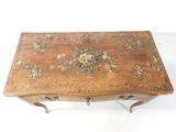 a small wooden table with a floral design on it