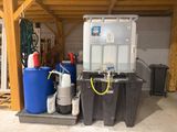 un réservoir d'eau et deux fûts bleus dans un garage