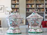 deux vases posés sur une table devant une bibliothèque
