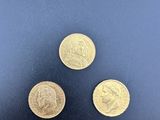 three gold coins with a picture of a woman on them