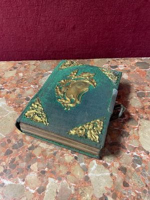 a small book on a marble table with a red wall behind it