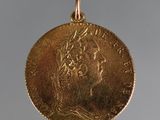 gros plan d'une pièce d'or portant un visage de femme