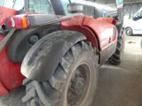 a red tractor that is parked in a garage