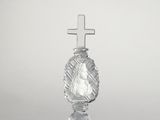 une image représentant un bougeoir en verre surmonté d'une croix