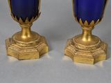 two blue vases sitting next to each other on a table