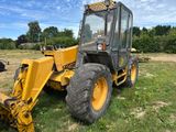 un tracteur jaune garé dans l'herbe
