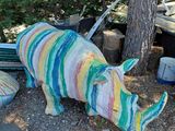 une statue de rhinocéros faite de laine, posée par terre
