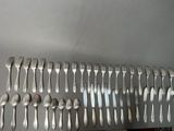 a lot of forks and spoons that are on the table