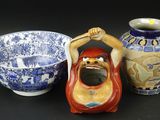 three vases and a bowl sitting on a table