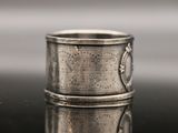 a close up of a silver ring on a reflective surface