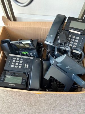 beaucoup de téléphones dans une boîte posée par terre