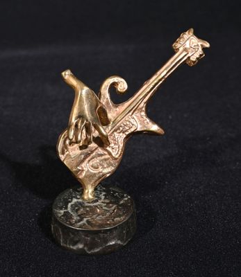 sculpture en bronze représentant une main tenant une guitare, posée sur un socle en marbre