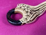 an image of a close up of a piece of jewelry on a purple surface