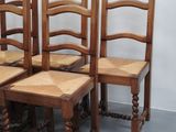 four wooden chairs sitting next to each other in a room