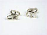 pair of silver cufflinks on white surface with white background