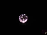 a purple diamond in the dark with a black background