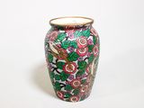 un vase avec un motif floral sur une surface blanche