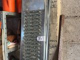 a metal grater sitting on a shelf in the corner of a room