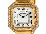 gros plan d'une montre-bracelet en or avec des chiffres romains