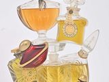 bottles of perfume are stacked on top of each other on a white surface