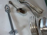 a lot of silver spoons and forks on the table