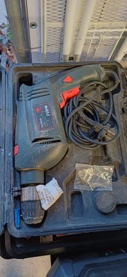 une boîte noire contenant des outils, posée par terre
