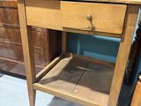 a wooden table with a drawer on it in a room