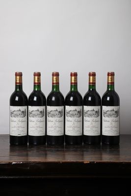 six bouteilles de vin alignées sur une table en bois